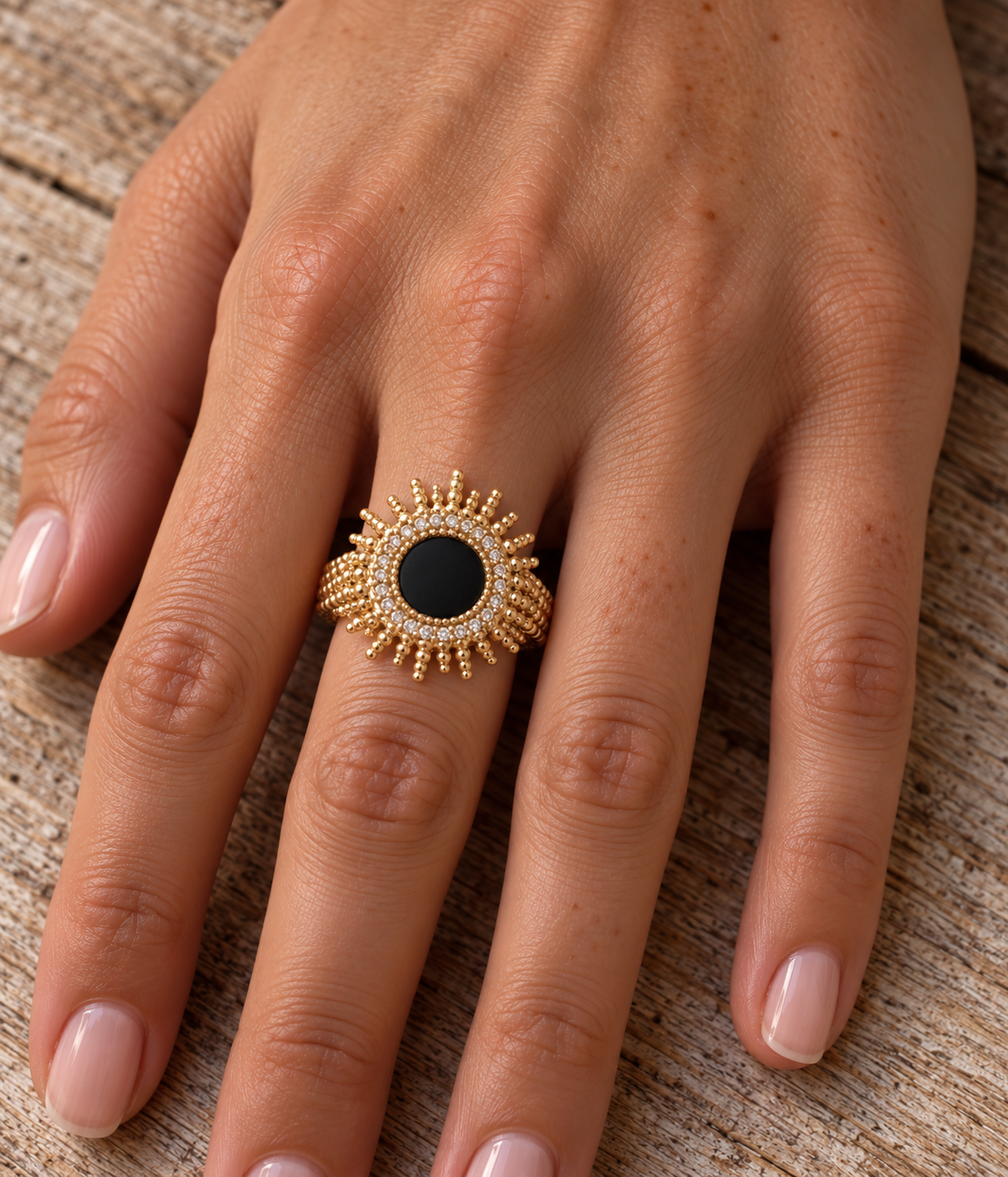 Bague Bora Bora plaquée or 3 microns, soleil avec agate noire centrale et oxydes de zirconium, portée